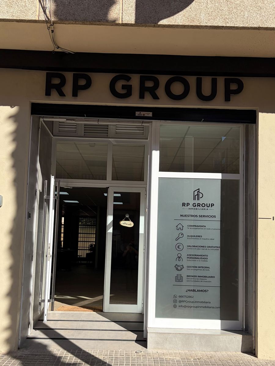 Fachada de RP Group Inmobiliaria con el rótulo sobre la puerta